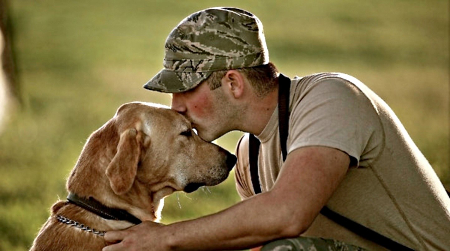 A military service member with a dog